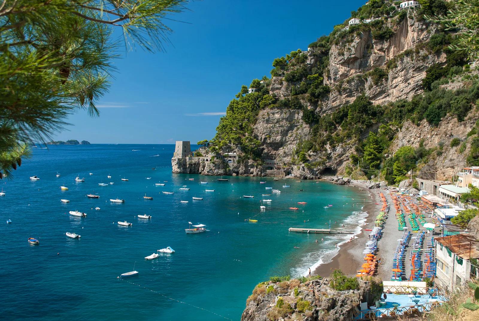 Best beaches Amalfi Coast cliff cove with turquoise water and boats