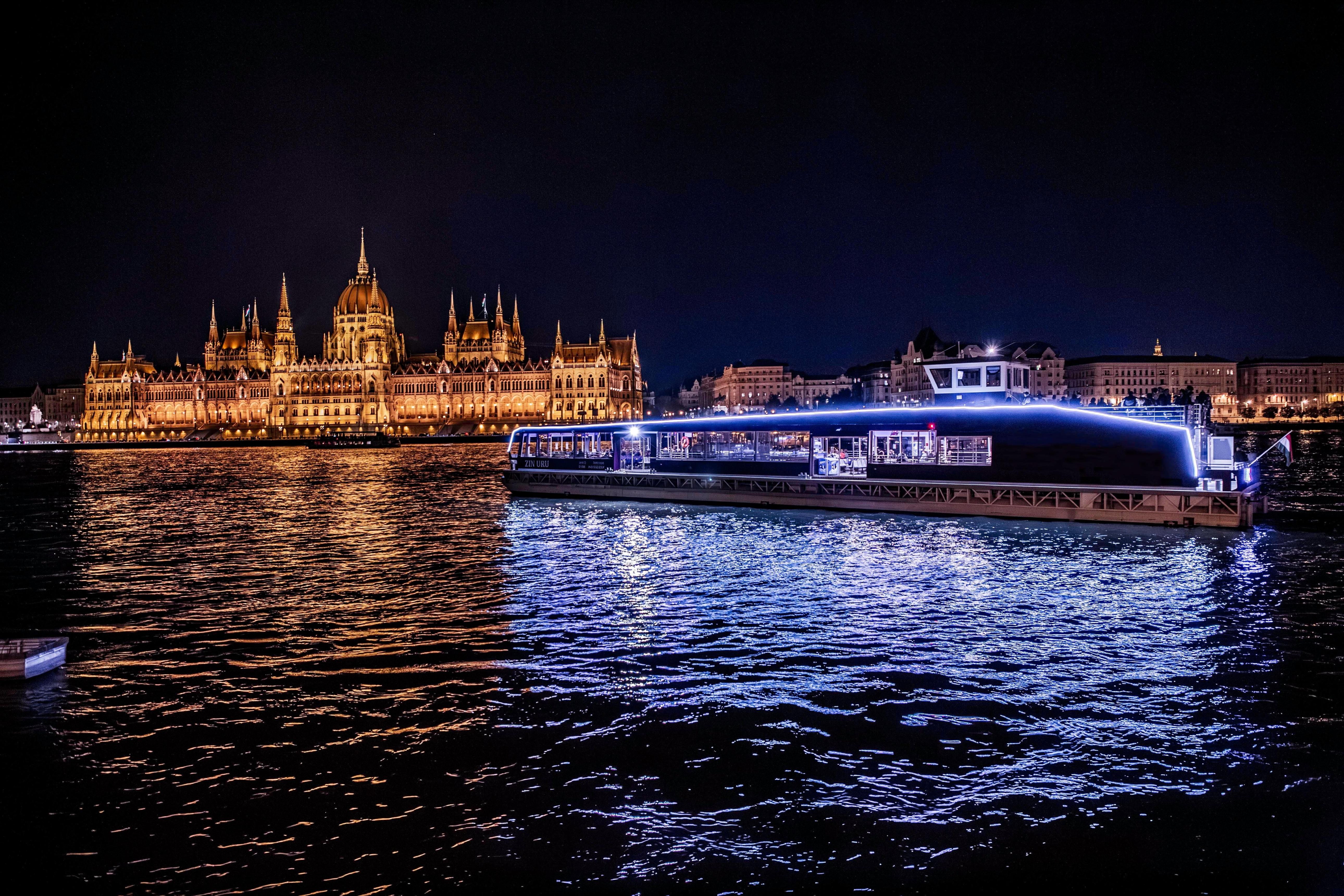Budapest 3 day itinerary evening river scene with illuminated Parliament and boat lights