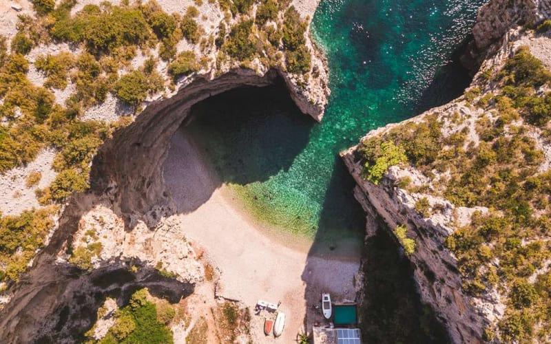 Hidden beaches Europe showing a secluded inlet with clear water and rock walls
