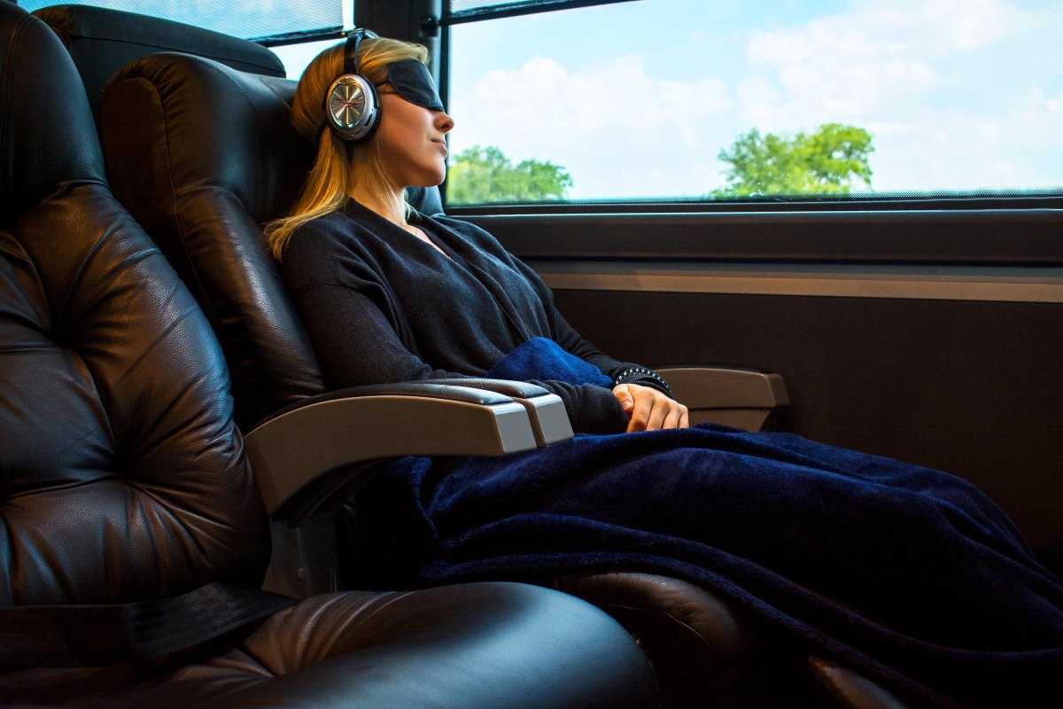 Bus passenger using travel pillow headphones