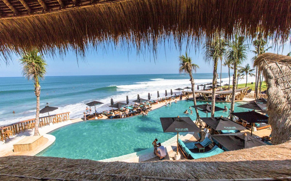 Bali beach club pool overlooking ocean sunset